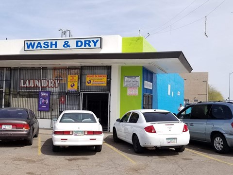a wash and dry car wash with cars parked in front of it