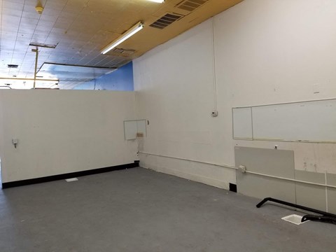 an empty room with a white wall and a whiteboard