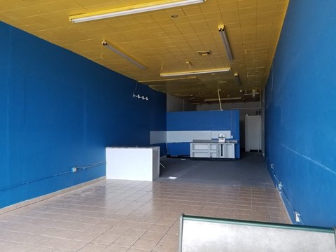 an empty room with a blue wall and a tile floor