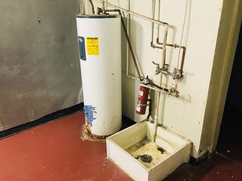 an old water heater and a white box on the floor
