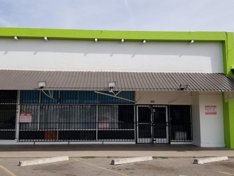 the front of a building with a fence and gates