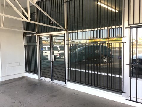 a car parked outside of a building with a gate on it