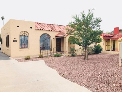 a house with a driveway and a tree in front of it