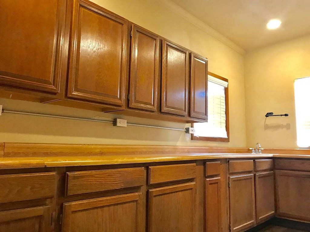 a kitchen with wooden cabinets and a sink and a window