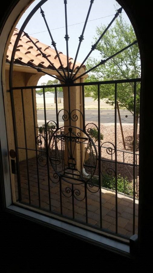 a window with a wrought iron gate in front of it