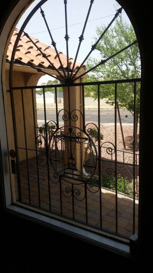a window with a wrought iron gate in front of it