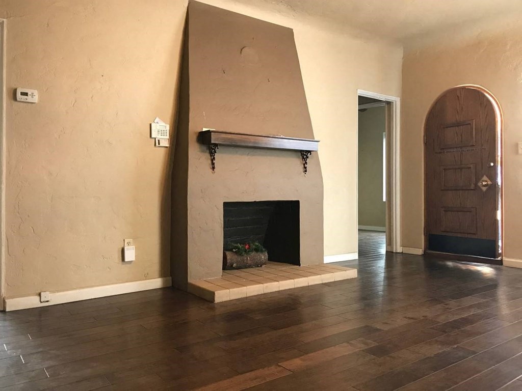a living room with a fireplace and a wooden floor