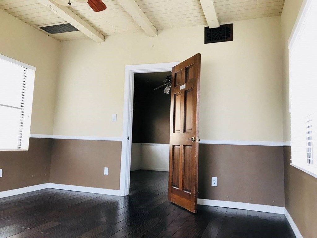 an empty room with wooden floors and a door