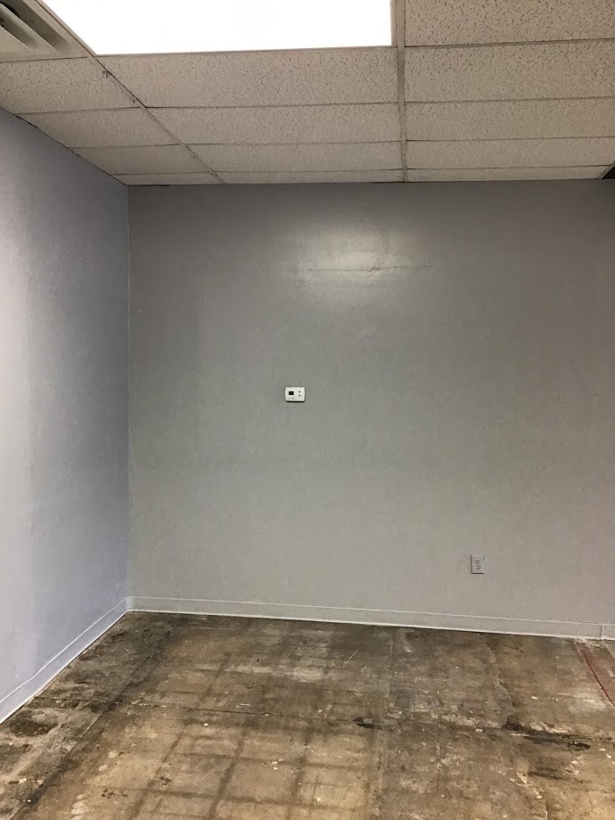 an empty room with a wall with an electrical outlet
