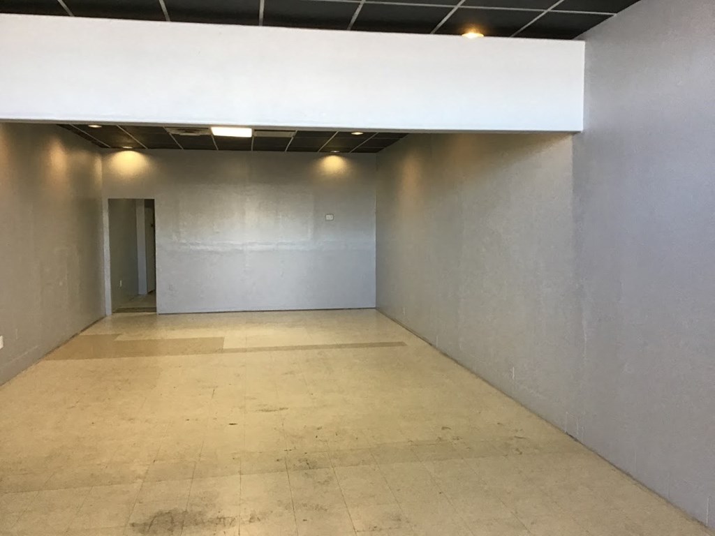 an empty room with a door in the end of it