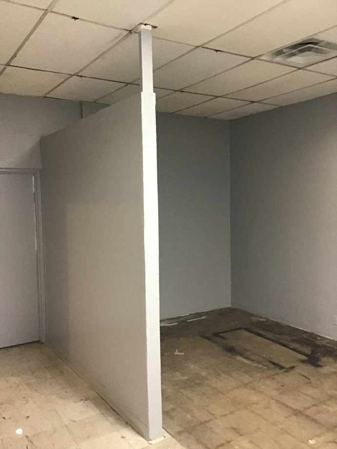 an empty room with a white pole in the corner