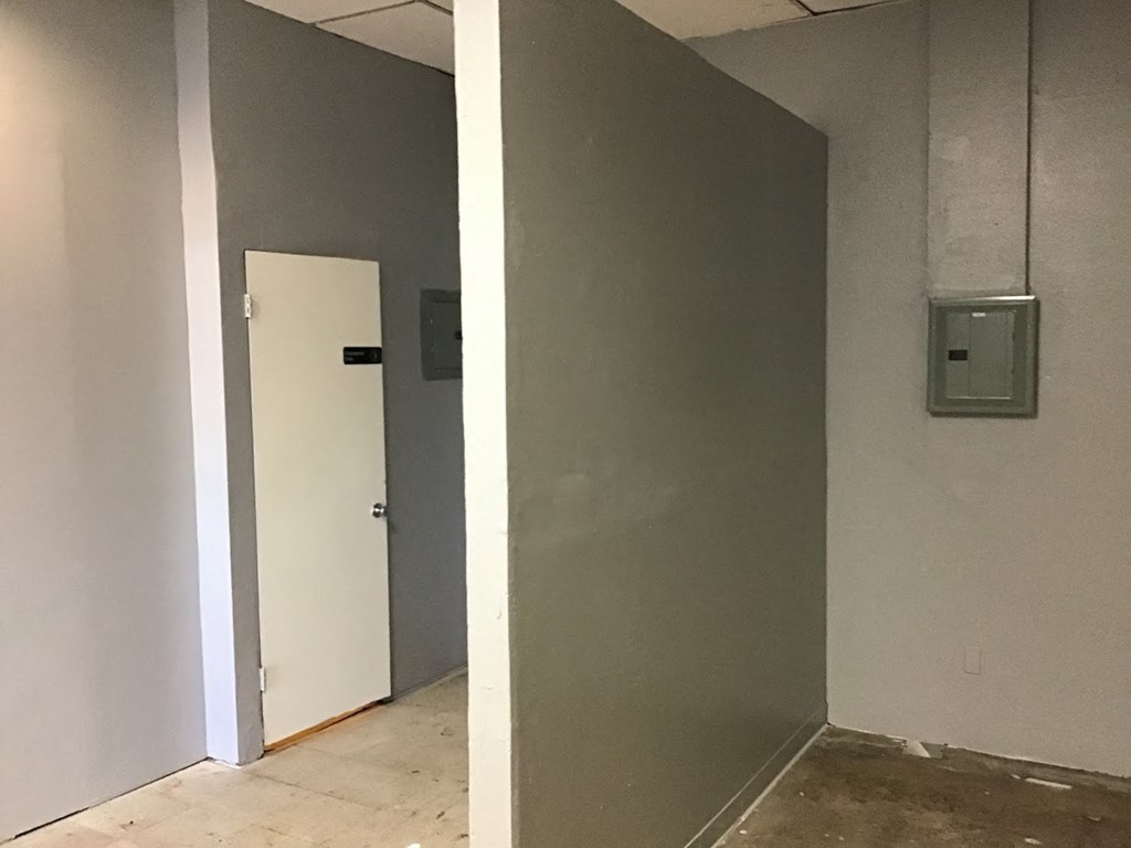 a hallway with a white door and a wall next to it