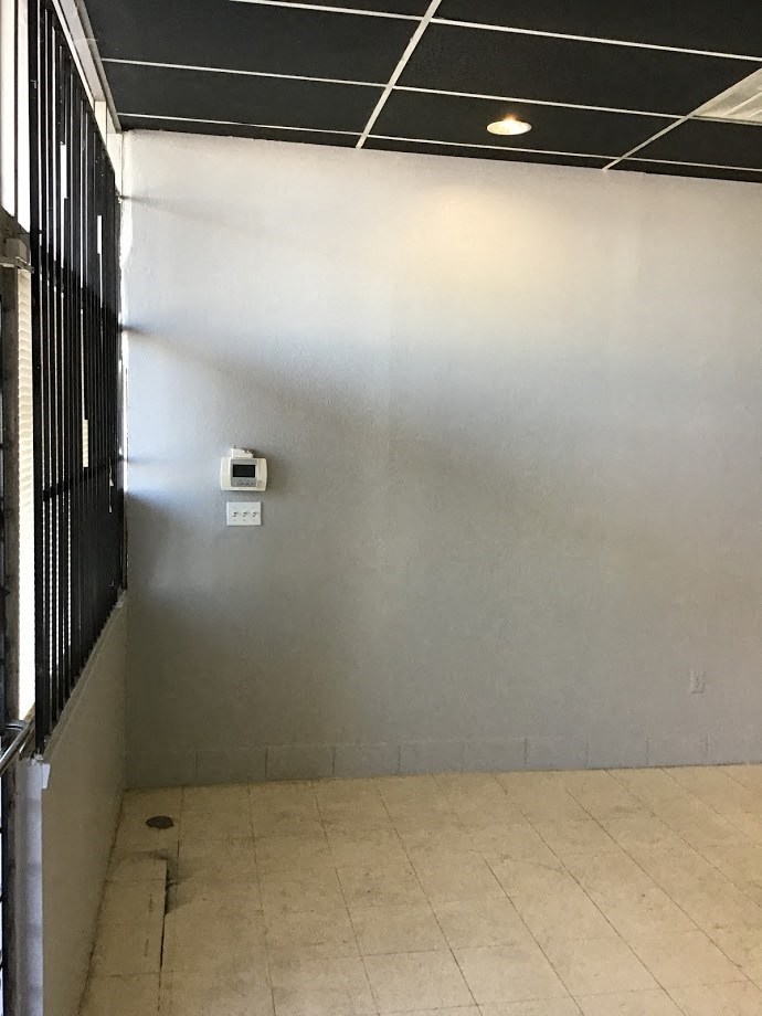 an empty room with a toilet and a white wall