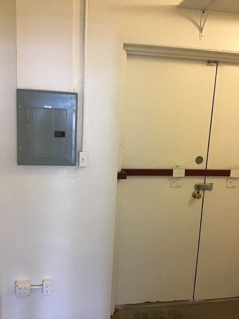 a door to a room with a sensor on the wall