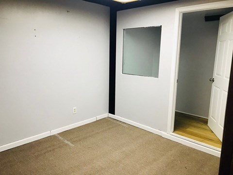 an empty room with a carpet and a door to a closet