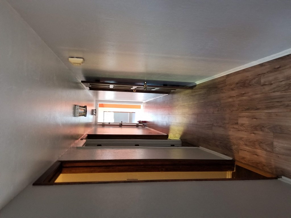 a view from the top of a staircase looking down into a room with wooden walls