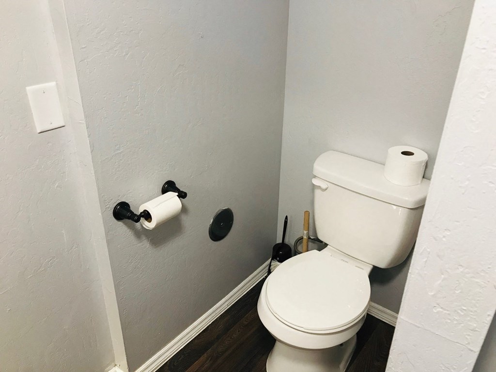a bathroom with a toilet and two rolls of toilet paper