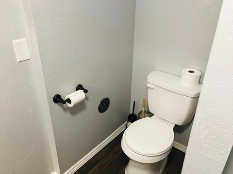 a bathroom with a toilet and two rolls of toilet paper