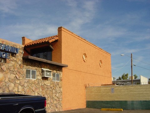 a brown building with a car parked in front of it