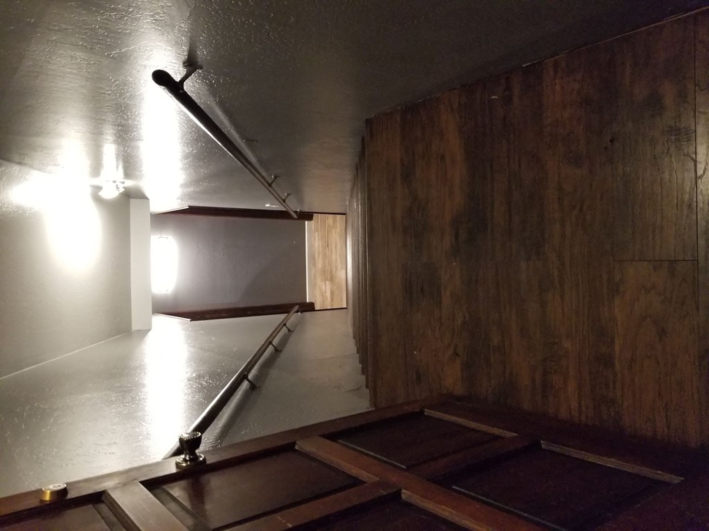 an empty room with a rail and a light on the wall