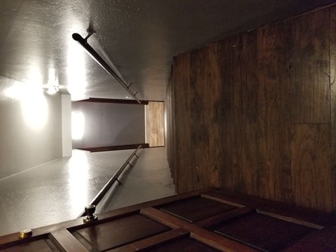 an empty room with a rail and a light on the wall