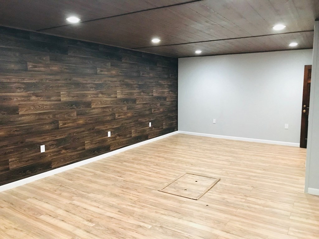 a living room with a wooden wall and a basketball court