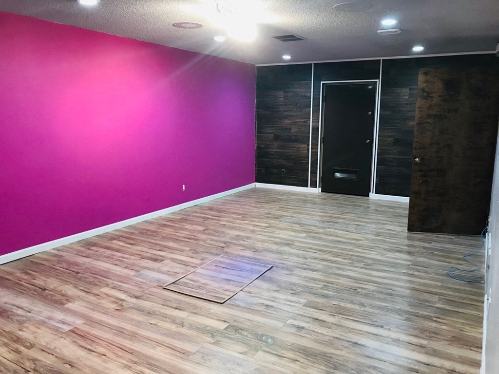 a room with a purple wall and wooden floors