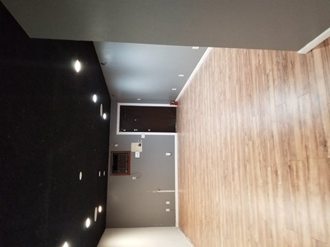 a hallway with a wooden wall and a black wall with a ceiling and a door