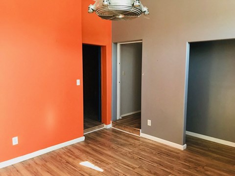a room with orange and gray walls and a wooden floor