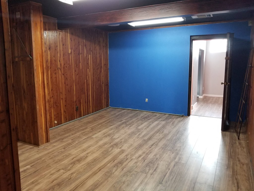 an empty room with a blue wall and wooden floors