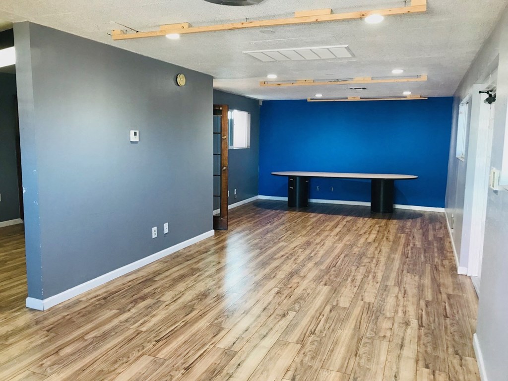 a room with a table and a blue wall and wood floors
