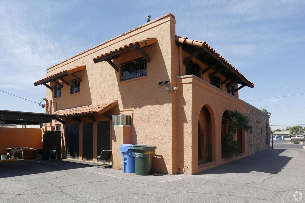 a brown building with a blue trash can in front of it