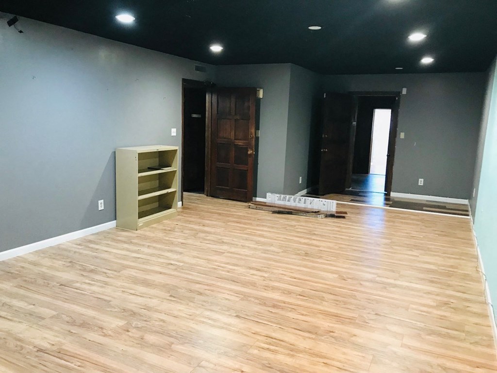 a living room with a hardwood floor and gray walls