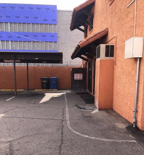 an empty alleyway between two buildings with a building in the background
