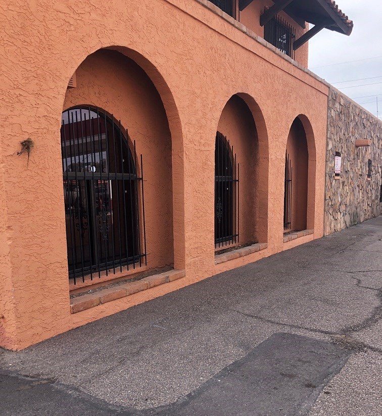 a brick building with arched windows and a sidewalk