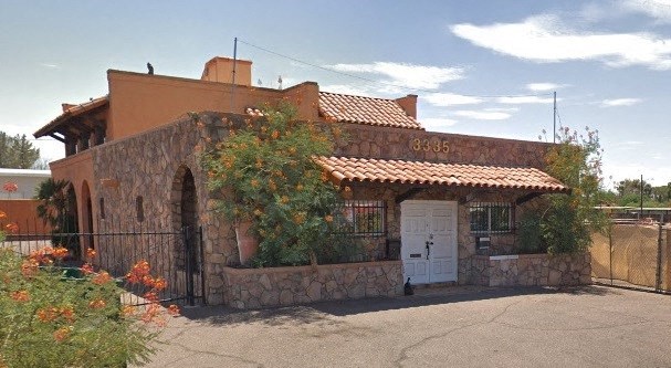 a brick house with a white door and a gate