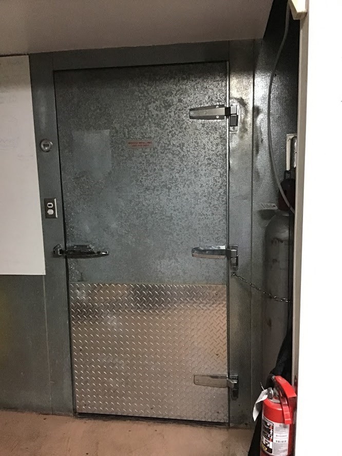 a metal door to a room with a fire extinguisher