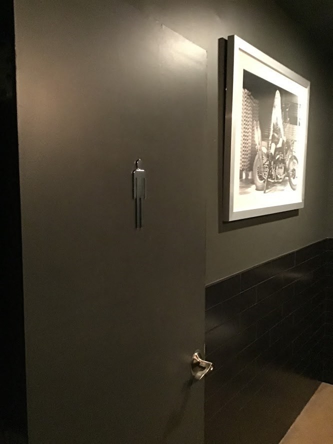 a bathroom door with a picture on the wall