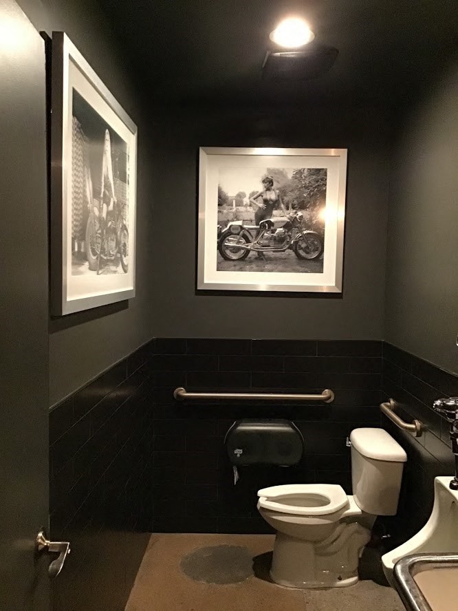 a bathroom with a toilet and a picture on the wall