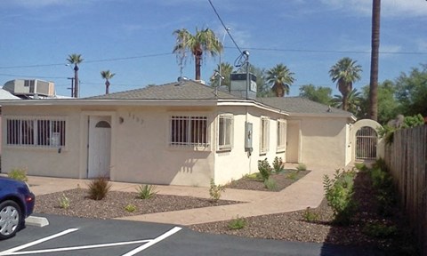 a house in a parking lot with palm trees