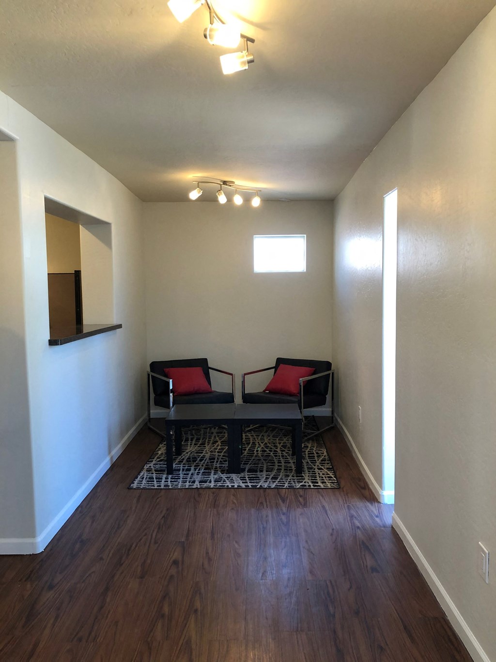 a living room with two chairs and a mirror