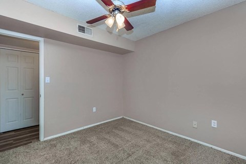 a bedroom with a ceiling fan and a door
