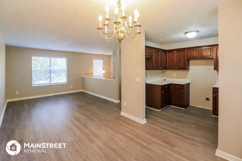 a kitchen and living room with wood flooring and a chandelier