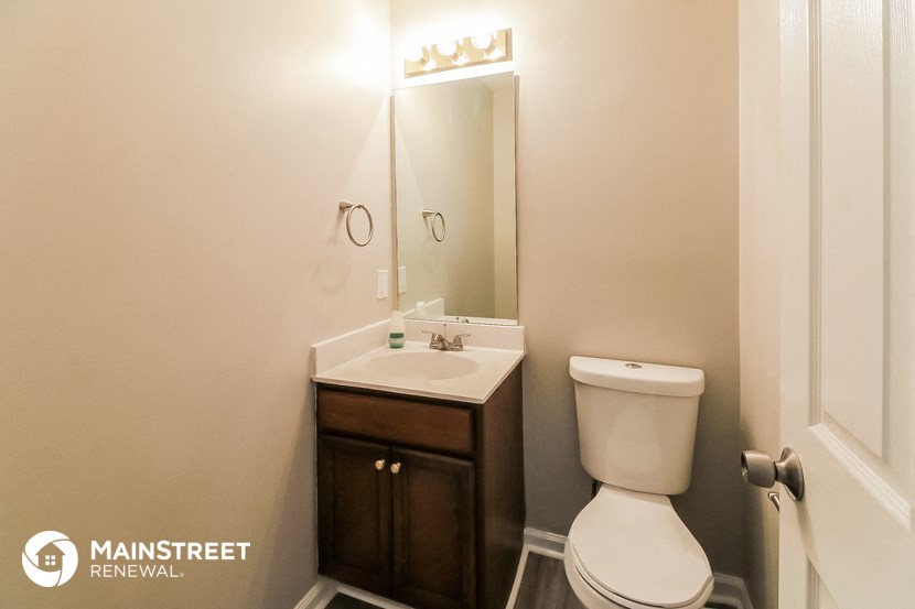 a small bathroom with a toilet sink and mirror