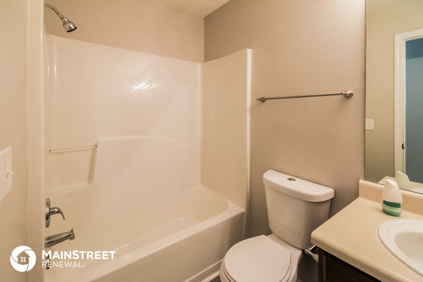 a bathroom with a shower and a toilet and a sink