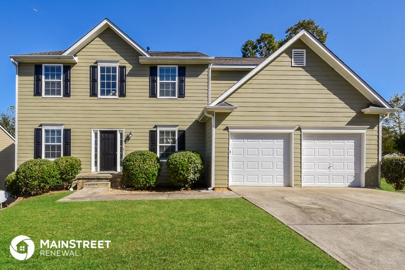 a yellow house with a white garage door