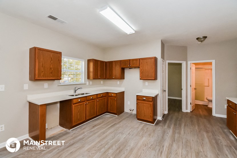 an empty kitchen with wooden cabinets and a white counter top