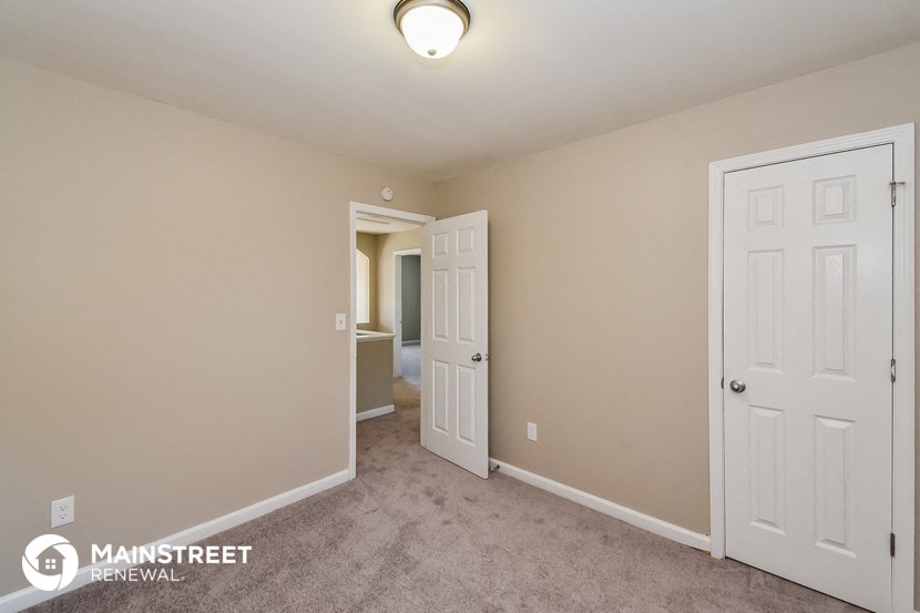 a bedroom with two closets and a door to a hallway