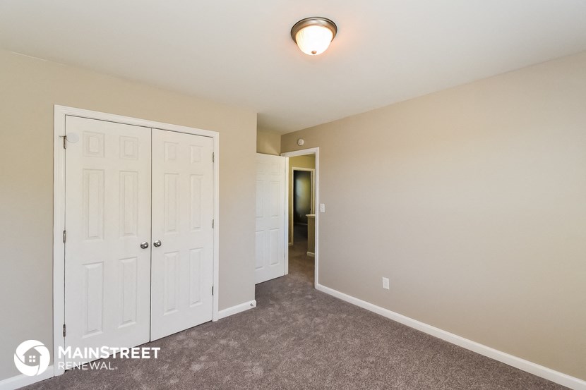 a bedroom with two closets and a door to a hallway