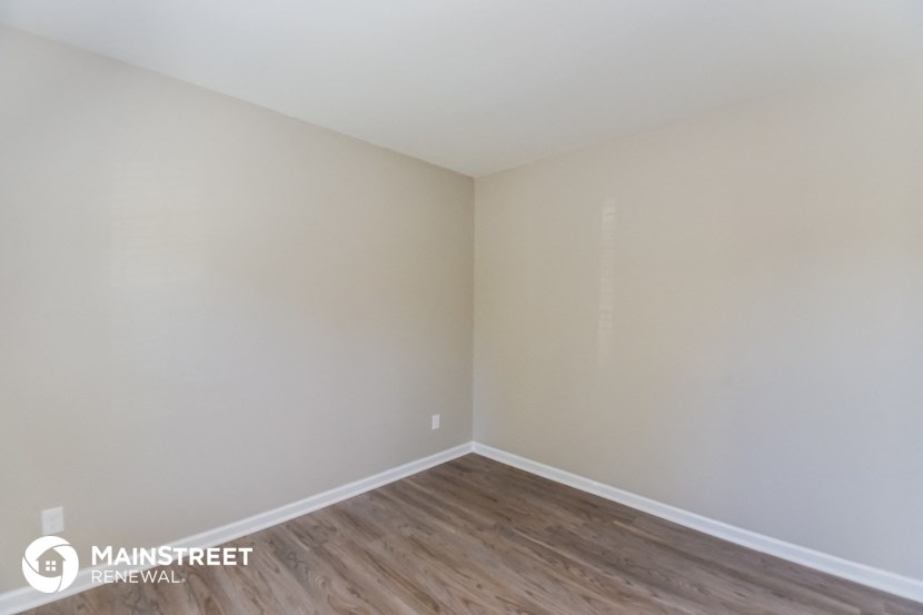 the interior of an empty room with wood flooring and white walls